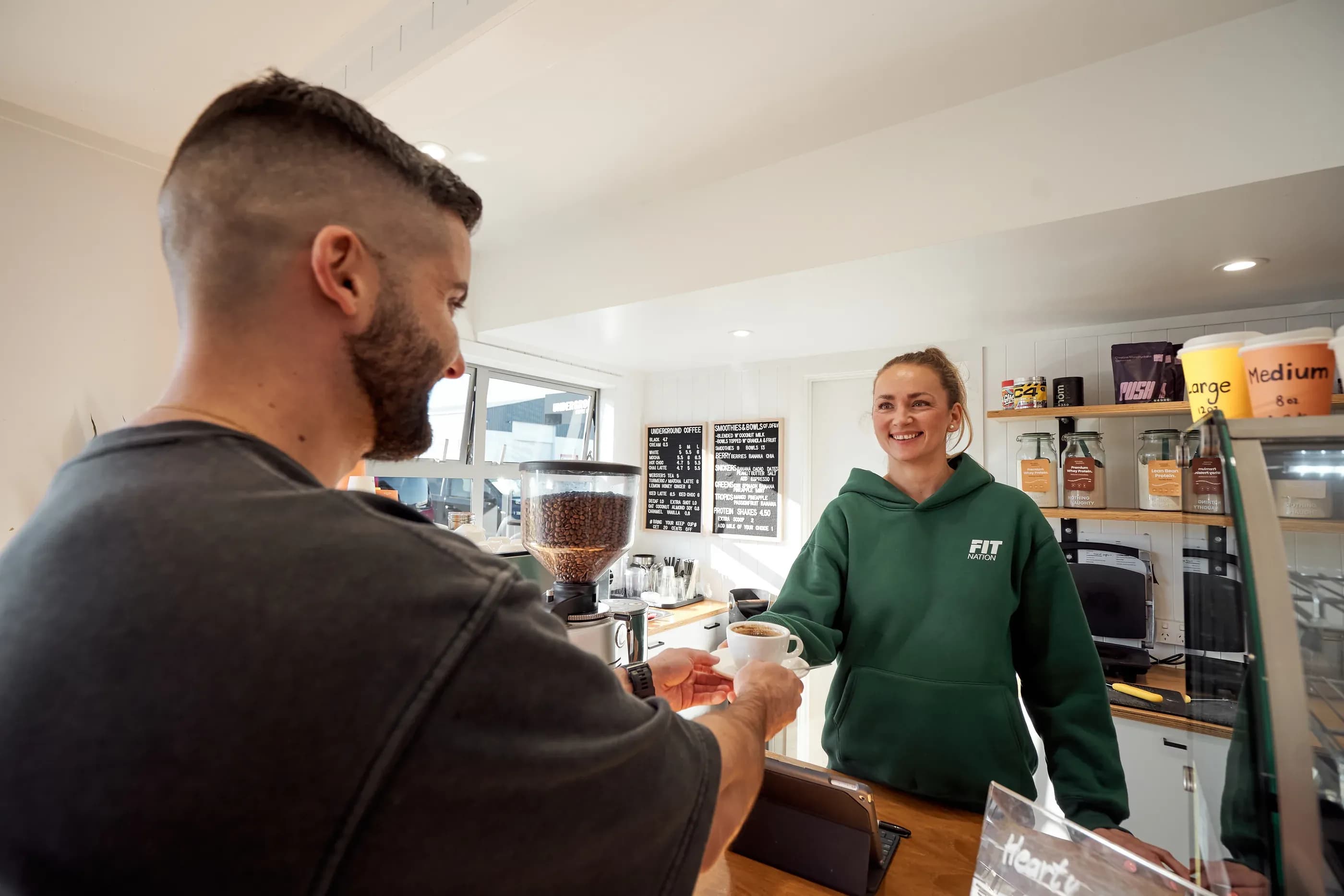 A member being served coffee at the Sol and Mar cafe counter inside Fit Nation Mount Maunganui